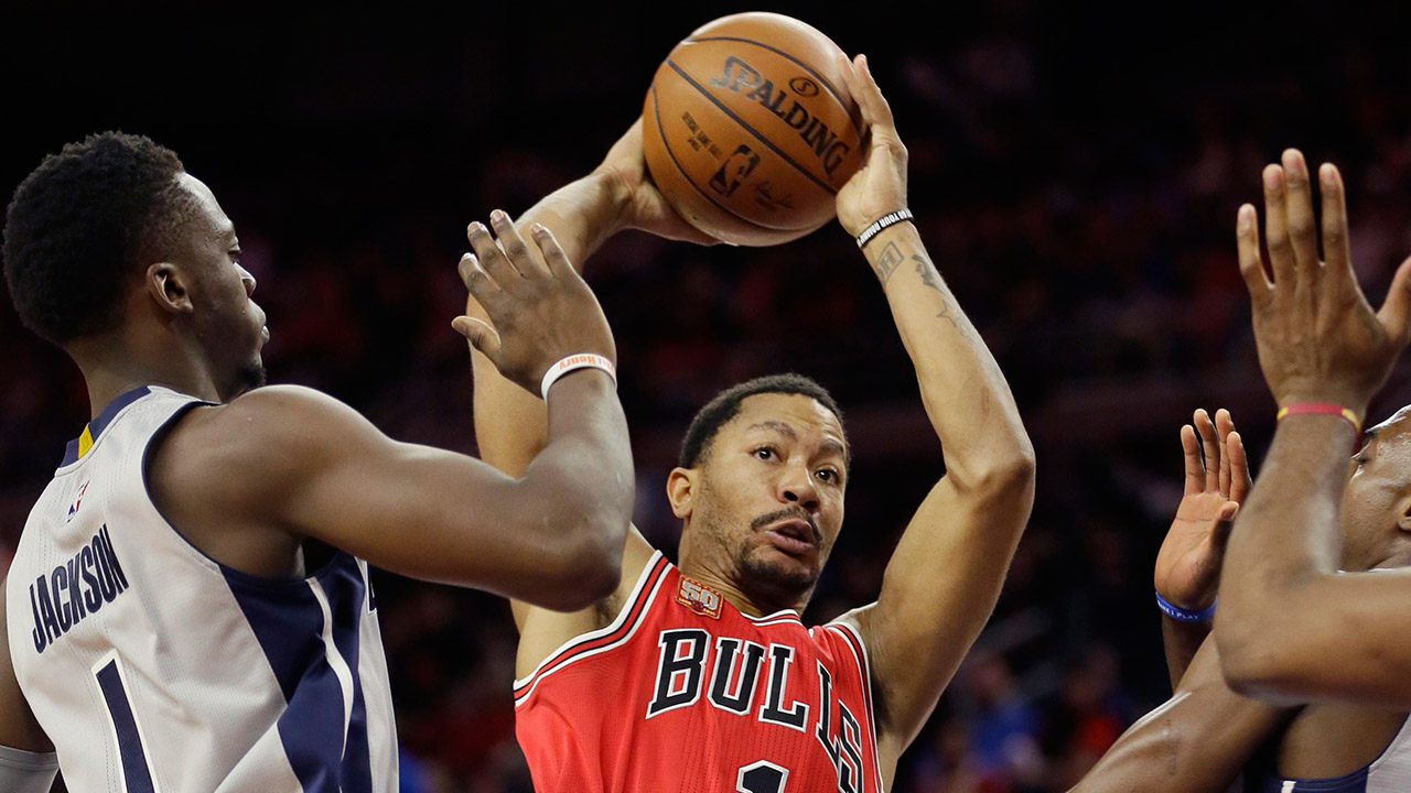 Chicago Bulls guard Derrick Rose (1) passes around the defense of Detroit Pistons guard Reggie Jackson (1) during the first half of an NBA basketball game, Monday, Jan. 18, 2016 in Auburn Hills, Mich. (Carlos Osorio/AP)