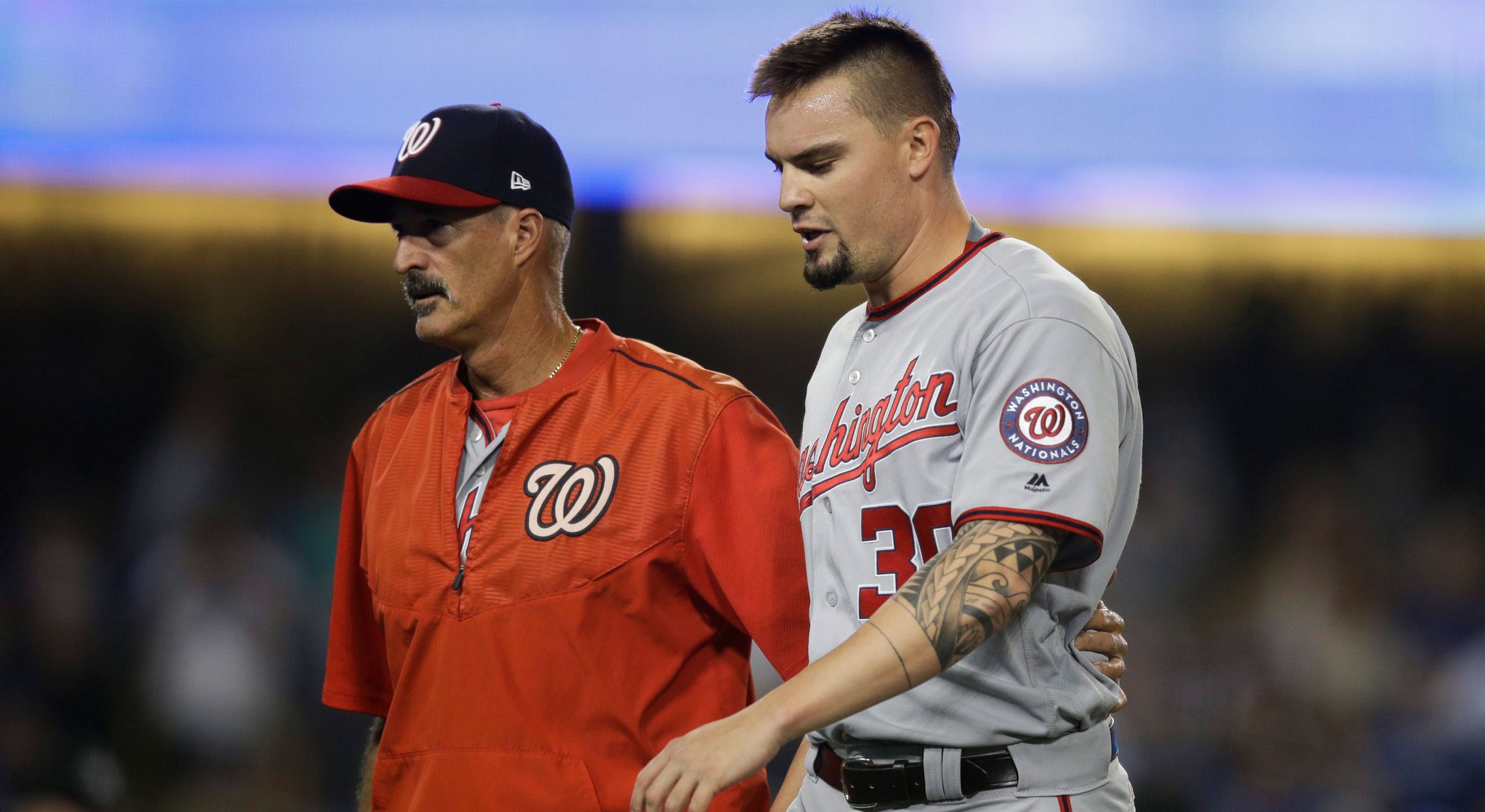 Now-former Washington Nationals' pitching coach Mike Maddux signs