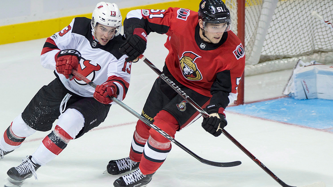 Logan Brown battles with Nico Hischier. (Andrew Vaughan/CP)