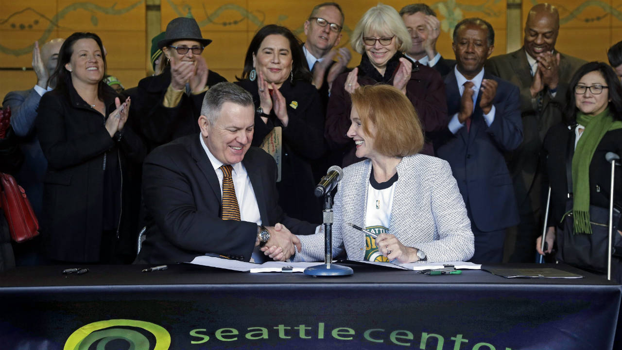 Seattle-Mayor-Jenny-Durkan,-right,-shakes-hands-with-Los-Angeles-based-Oak-View-Group-CEO-Tim-Leiweke-after-they-signed-an-agreement-to-renovate-KeyArena,-Wednesday,-Dec.-6,-2017,-in-Seattle.-Durkan-said-that-the-deal-is-the-best-path-right-now-for-Seattle-to-get-an-NHL-team-and-bring-back-the-SuperSonics.-(Elaine-Thompson/AP)