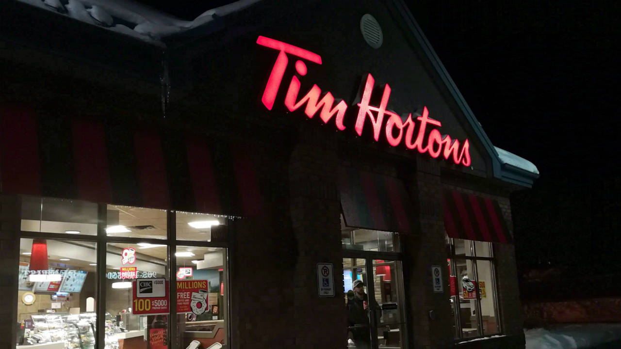 A-customer-walks-out-of-a-Tim-Hortons-restaurant.-(Doug-Ives/CP)