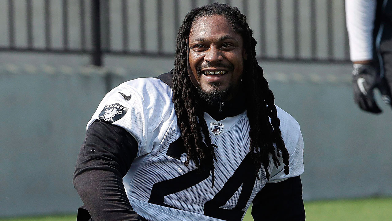 Raiders RB Marshawn Lynch sits during national anthem