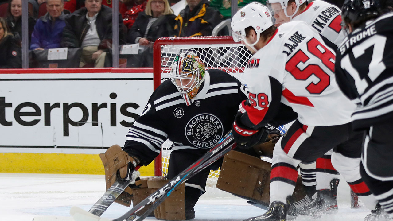 Chicago Blackhawks goaltender Collin Delia (60) makes a stop on Ottawa Senators defenceman Maxime Lajoie (58). (Jeff Haynes/AP)