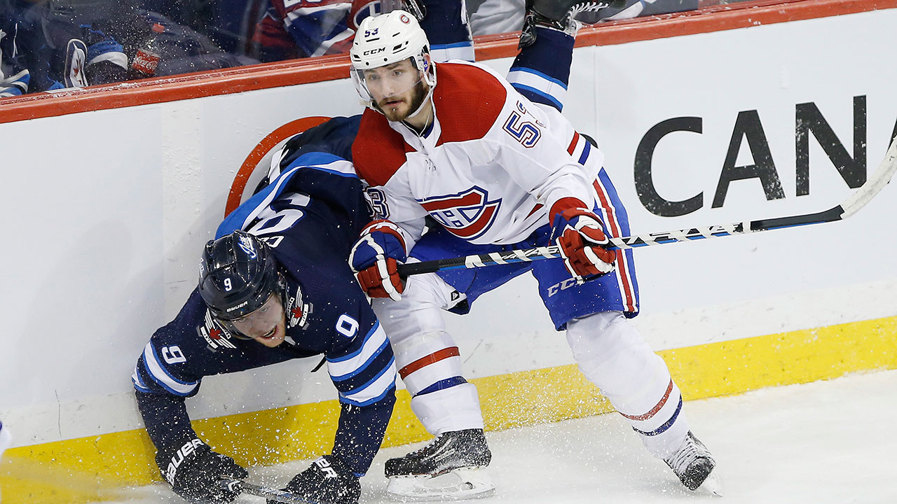 Montreal Canadiens' Victor Mete checks Winnipeg Jets' Andrew Copp. (John Woods/CP)