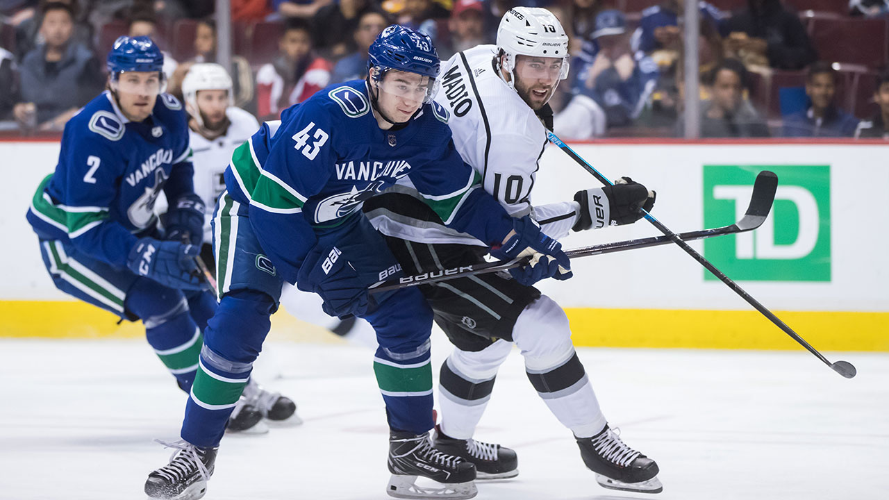 Vancouver Canucks' Quinn Hughes (43) checks Los Angeles Kings' Michael Amadio (10). (Darryl Dyck/CP)