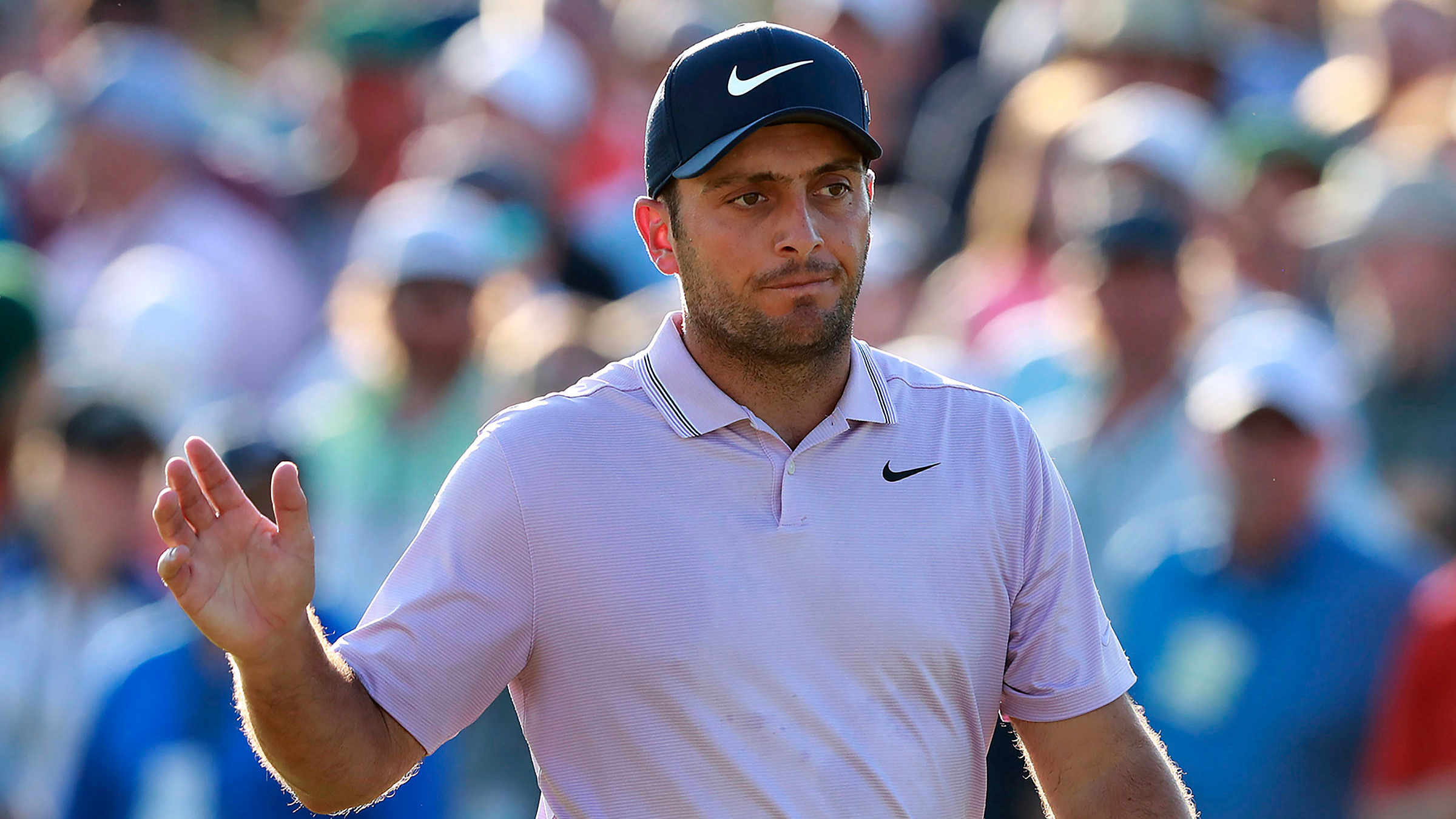 Francesco Molinari waves on the 18th green after making a par to finish at 13 under for the lead after three rounds at the Masters. (Curtis Compton/Atlanta Journal-Constitution via AP)