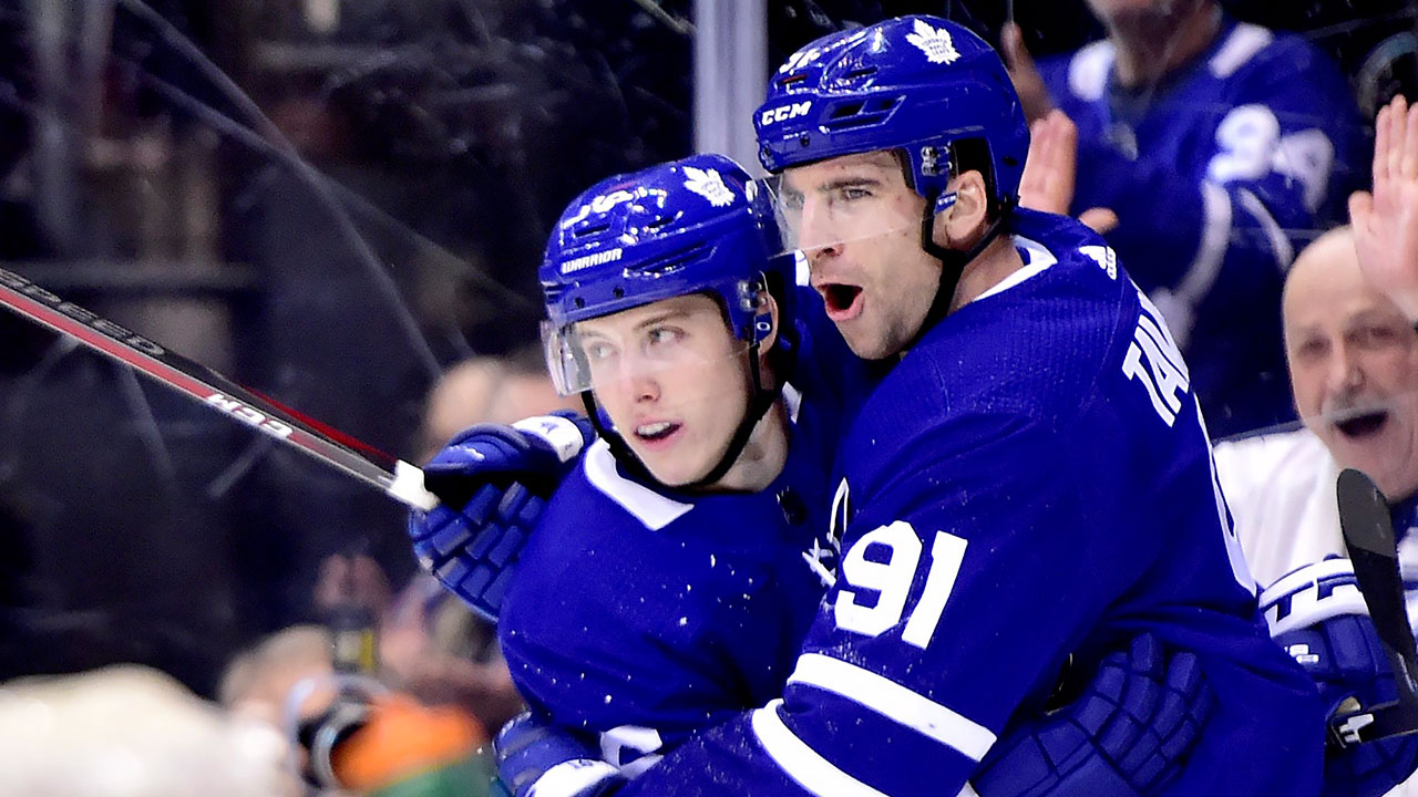 Toronto Maple Leafs' Auston Matthews (34) celebrates scoring his team's  fourth goal with teammate John Tavares, left, as Mitchell Marner skates in  during second period NHL hockey action against the Minnesota Wild