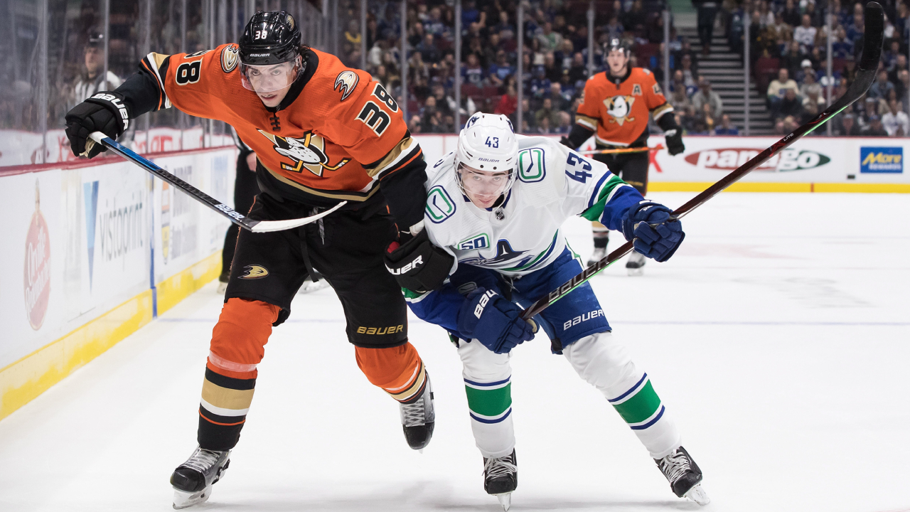 Anaheim Ducks' Derek Grant, left, attempts to skate past Vancouver Canucks' Quinn Hughes during the first period of an NHL hockey game in Vancouver, on Sunday February 16, 2020. (Darryl Dyck/CP)