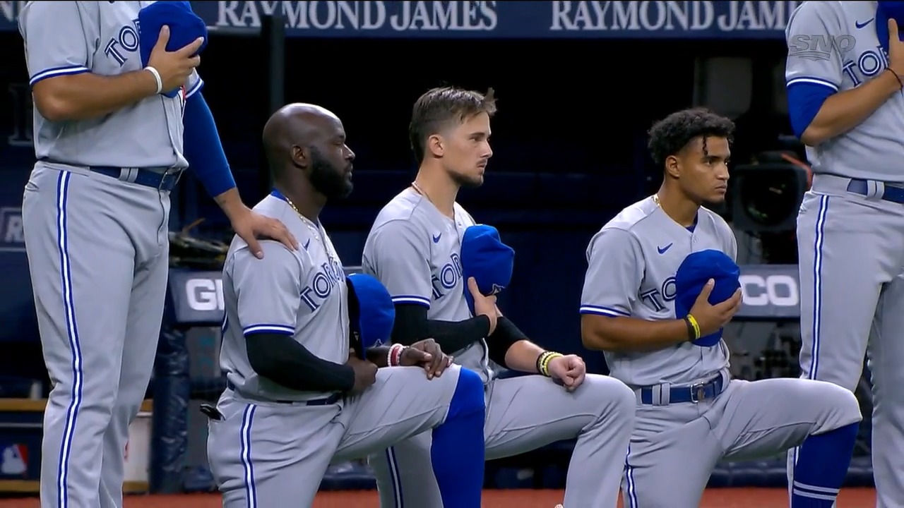 Members of the Blue Jays put their hats back on after the national anthem  during the opening da …