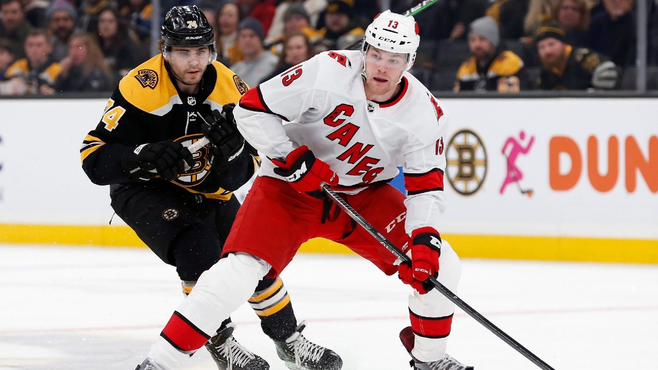 Carolina Hurricanes' Warren Foegele (13) handles the puck in front of Boston Bruins' Jake DeBrusk (74) during the first period of an NHL hockey game in Boston, Tuesday, Dec. 3, 2019. (Michael Dwyer/AP)