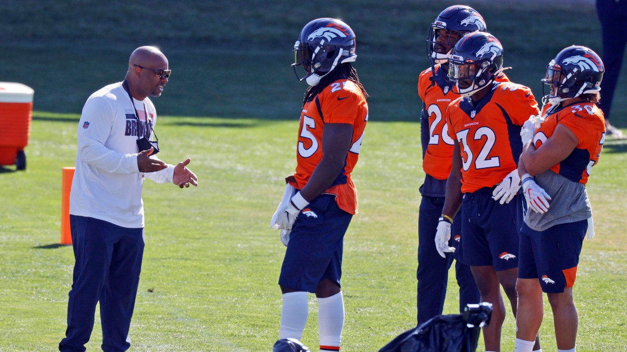 Denver Broncos running backs coach Curtis Modkins while taking