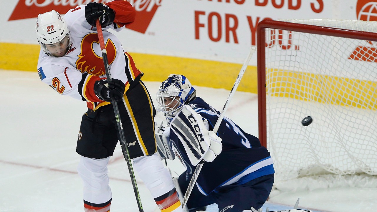 Winnipeg Jets goaltender Michael Hutchinson (34) stops the shot from Calgary Flames' Drew Shore (22) during first period of NHL pre-season game action in Winnipeg on Thursday, October 1, 2015. (John Woods / CP)