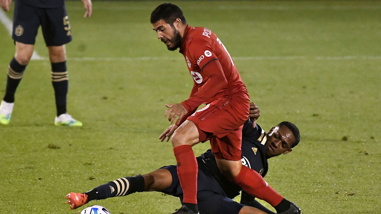 Toronto FC's Alejandro Pozuelo, top, pressures Philadelphia Union's Jose "El Brujo" Martinez during the first half of an MLS soccer match. (Jessica Hill/AP)