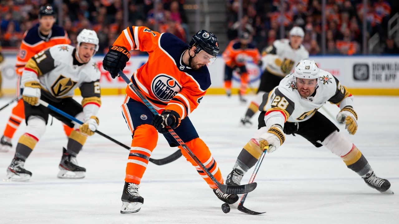 Edmonton Oilers Kris Russell (4) is checked by Vegas Golden Knights' William Carrier (28) during first period NHL action. (Codie McLachlan/CP)