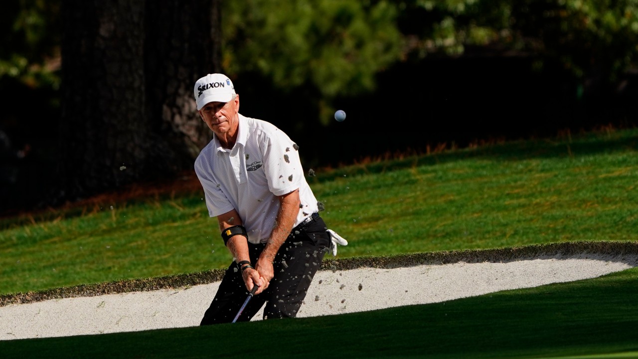 Larry Mize chips out of a bunker on the seventh hole during the first round of the Masters golf tournament. (Matt Slocum/AP)