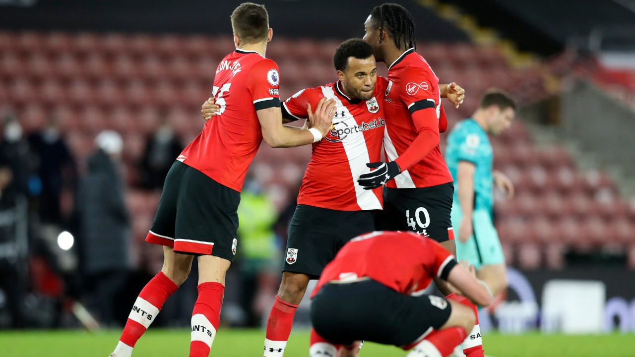 Southampton's Jan Bednarek, left, Ryan Bertrand and San Nlundulu, right, embrace as they celebrate a win over Liverpool. (Noami Baker/AP)