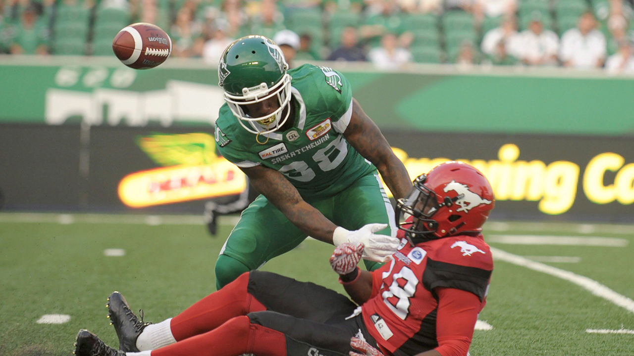 Saskatchewan Roughriders linebacker Alexandre Chevrier gets tangled up with the Calgary Stampeders defensive back Brandon Smith during first half pre-season CFL action at Mosaic Stadium in Regina on Friday, June 8, 2018. (Mark Taylor/CP)