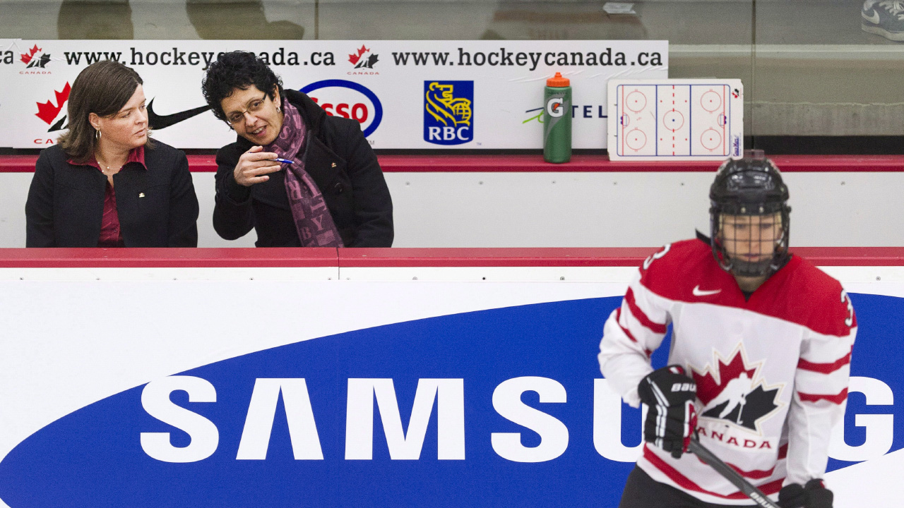 Danielle Goyette, centre, and Lisa Haley, left. watch from the bench. (Larry MacDougal/CP)