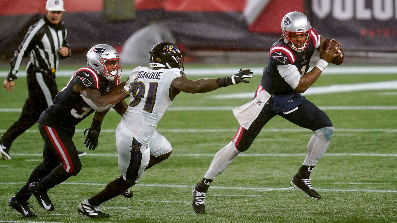 New England Patriots quarterback Cam Newton, right, scrambles away from Baltimore Ravens defensive end Yannick Ngakoue in the second half of an NFL football game. (Elise Amendola/AP)