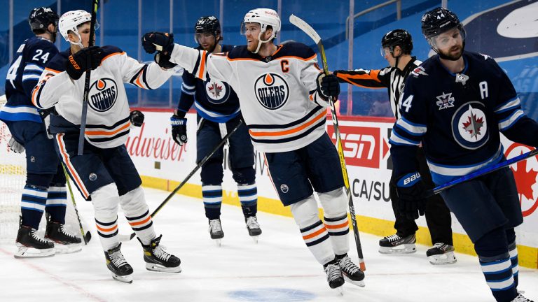 Edmonton Oilers’ Connor McDavid (97) celebrates his goal with teammate Jesse Puljujarvi (13) during first period NHL action against the Winnipeg Jets, in Winnipeg, Monday, April 26, 2021. (Fred Greenslade/CP)