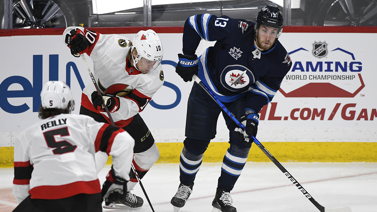 Winnipeg Jets' Pierre-Luc Dubois (13) looks to pass the puck past Ottawa Senators' Ryan Dzingel (10) during first period NHL action in Winnipeg. (Fred Greenslade/AP)