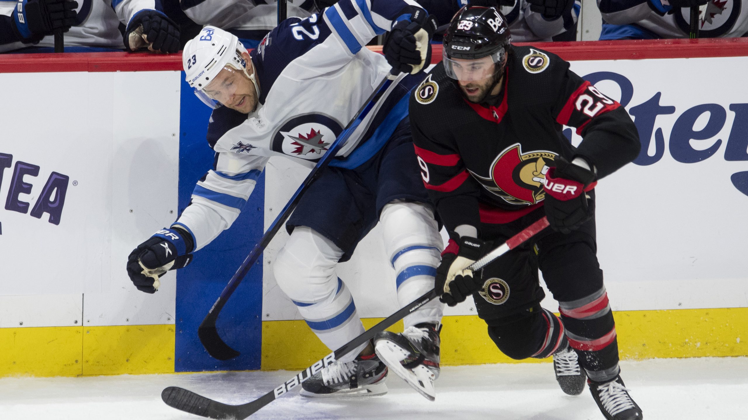 Ottawa Senators centre Michael Amadio takes the puck away from Winnipeg Jets centre Trevor Lewis along the boards during first period NHL action Monday April 12, 2021 in Ottawa. THE CANADIAN PRESS/Adrian Wyld