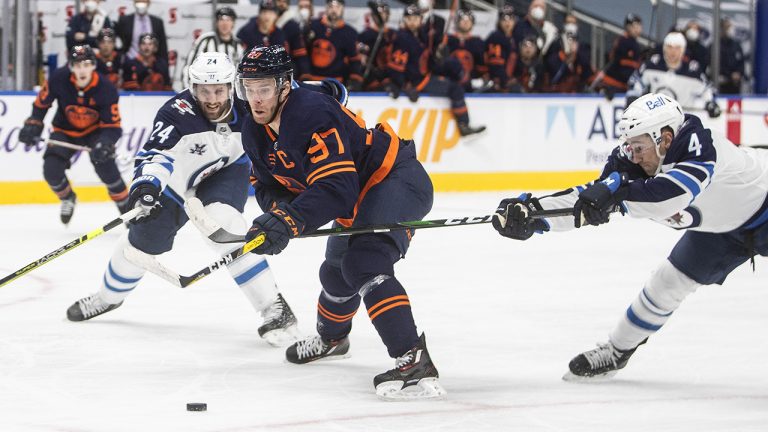 Edmonton Oilers' Connor McDavid (97) is chased by Winnipeg Jets' Derek Forbort (24) and Neal Pionk (4) during second period NHL action in Edmonton. (Jason Franson/CP)