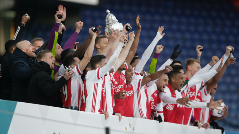 Ajax players and Ajax's head coach Erik ten Hag, far left, celebrate with the trophy after winning the TOTO KNVB Cup final soccer match between Ajax and Vitesse at De Kuip stadium in Rotterdam, Netherlands, Sunday April 18, 2021. (Peter Dejong / AP)