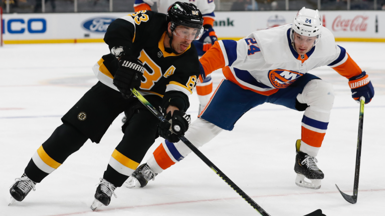 Boston Bruins' Brad Marchand goes around New York Islanders defenceman Scott Mayfield during the first period of an NHL hockey game Friday, April 16, 2021, in Boston. (Winslow Townson / AP) 