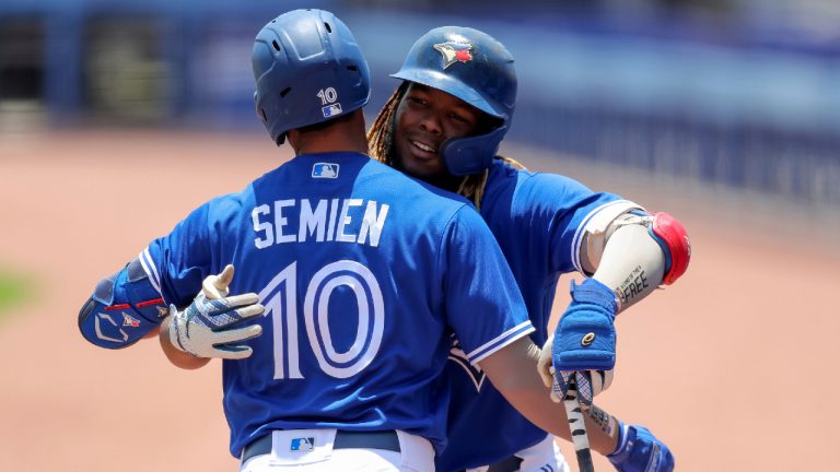 Toronto Blue Jays' Vladimir Guerrero Jr. congratulates Marcus Semien on his first-inning home run versus the Philadelphia Phillies on May 16, 2021. (AP Photo/Mike Carlson)