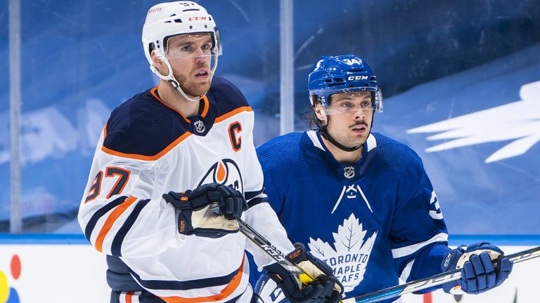 Connor McDavid of the Edmonton Oilers skates alongside Toronto Maple Leafs forward Auston Matthews. (Mark Blinch/Getty)