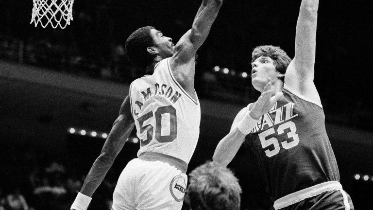 In this Nov. 11, 1983, photo, Utah Jazz center Mark Eaton , right, puts a hook shot up and over the outstretched hand of Houston Rocket center Ralph Sampson during the first period of an NBA basketball game at the Summit in Houston. (R.J. Carson/AP)