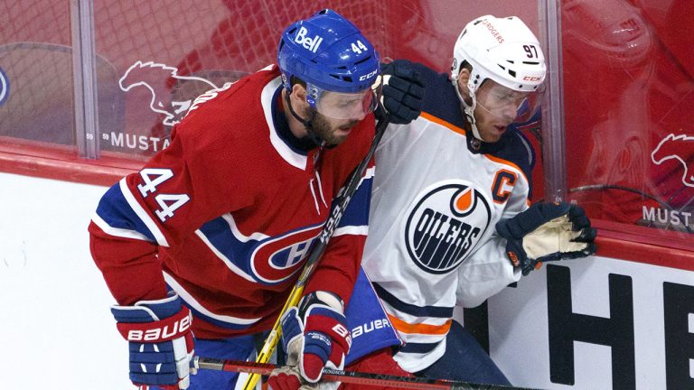 Edmonton Oilers' Connor McDavid takes a hit from Montreal Canadiens' Joel Edmundson during first period NHL hockey action in Montreal on Monday, April 5, 2021. THE CANADIAN PRESS/Paul Chiasson