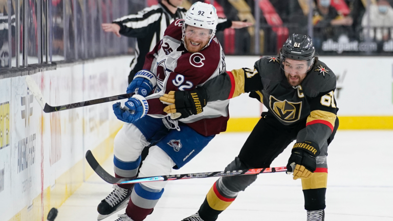 Vegas Golden Knights right wing Mark Stone (61) and Colorado Avalanche left wing Gabriel Landeskog (92) battle for the puck during the third period of an NHL hockey game Monday, May 10, 2021, in Las Vegas. (John Locher / AP) 