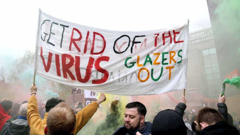 Fans holds up a banner as they protest against the Glazer family, owners of Manchester United, before their Premier League match against Liverpool at Old Trafford, Manchester, England, Sunday, May 2, 2021. (Barrington Coombs/PA via AP)