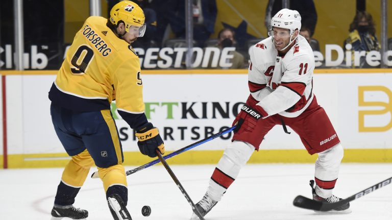 Nashville Predators left wing Filip Forsberg (9) blocks a shot by Carolina Hurricanes center Jordan Staal (11) during the first period of an NHL hockey game Saturday, May 8, 2021, in Nashville, Tenn. (AP Photo/Mark Zaleski)