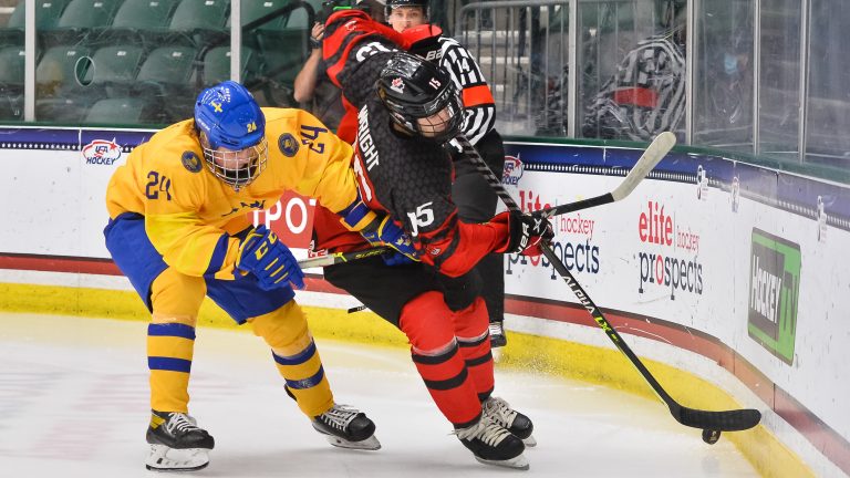 Canada's Shane Wright battles for the puck. 
(via Hockey Canada Twitter)