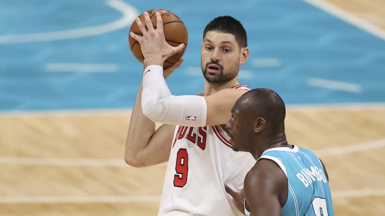 Chicago Bulls center Nikola Vucevic, left, looks to pass the ball as Charlotte Hornets center Bismack Biyombo (8) defends during the second half of an NBA basketball game in Charlotte, N.C., Thursday, May 6, 2021. (Nell Redmond/AP)