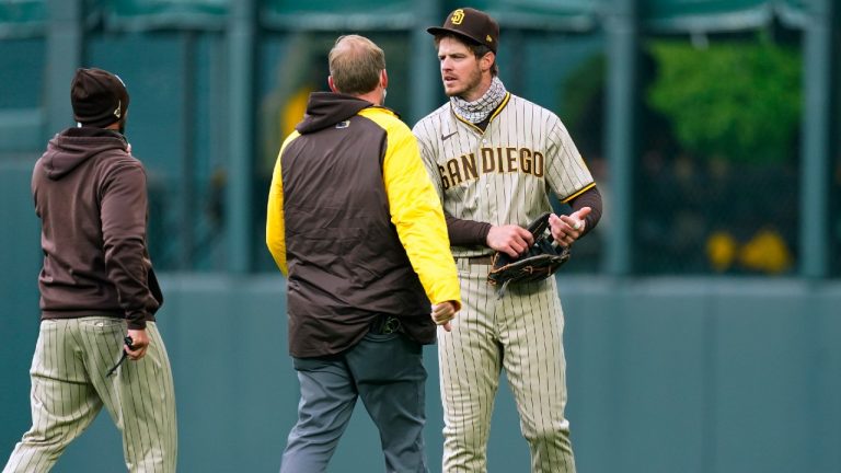 San Diego Padres manager Jayce Tingler, left, and a trainer check on right fielder Wil Myers after he ran into the wall catching a fly ball hit by Colorado Rockies' Garrett Hampson during the first inning of a baseball game Tuesday, May 11, 2021, in Denver. (David Zalubowski/AP)