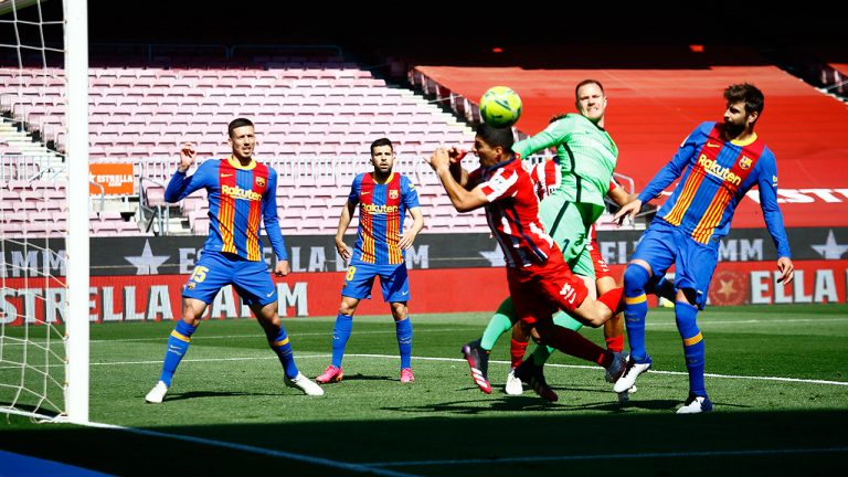 Atletico Madrid's Luis Suarez, centre, is challenged by Barcelona's goalkeeper Marc-Andre ter Stegen, second right, and Barcelona's Gerard Pique during the Spanish La Liga soccer match between FC Barcelona and Atletico Madrid at the Camp Nou stadium in Barcelona, Spain, Saturday, May 8, 2021. (Joan Monfort/AP)