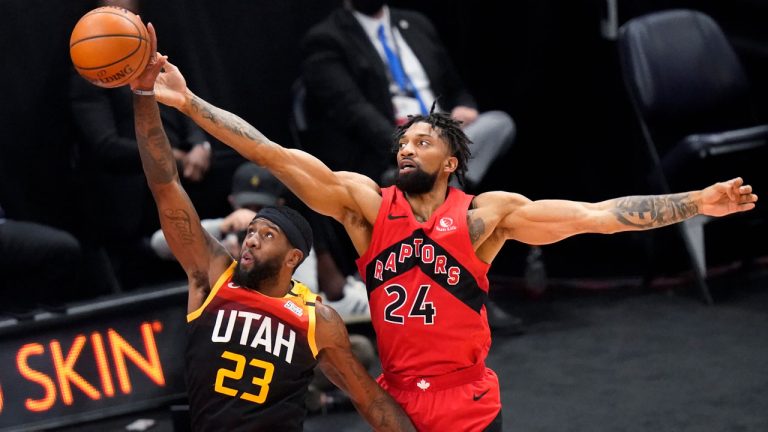 Toronto Raptors center Khem Birch (24) and Utah Jazz forward Royce O'Neale (23) reach for a rebound during the first half of an NBA basketball game. (Rick Bowmer/AP)