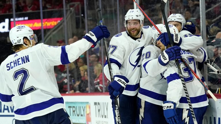 Tampa Bay Lightning defenceman Luke Schenn (2) congratulates centre Barclay Goodrow, right, along with defenceman Victor Hedman (77), center Yanni Gourde (37) and centre Blake Coleman (20) following Goodrow's goal during the third period in Game 1 of an NHL hockey Stanley Cup second-round playoff series against the Carolina Hurricanes in Raleigh, N.C., Sunday, May 30, 2021. (Gerry Broome/AP)