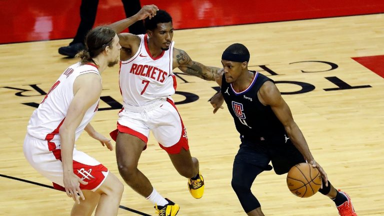 Los Angeles Clippers' Rajon Rondo (4) drives on Houston Rockets' Armoni Brooks (7) and Kelly Olynyk during the second quarter of an NBA basketball game Friday, May 14, 2021, in Houston. (Bob Levey/Pool Photo via AP)