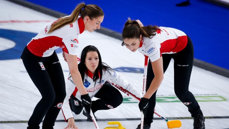 Team Canada skip Kerri Einarson makes a shot as lead Briane Meilleur, left, and second Shannon Birchard sweep against Estonia at the Women's World Curling Championship in Calgary, Alta., Wednesday, May 5, 2021. (Jeff McIntosh/CP)