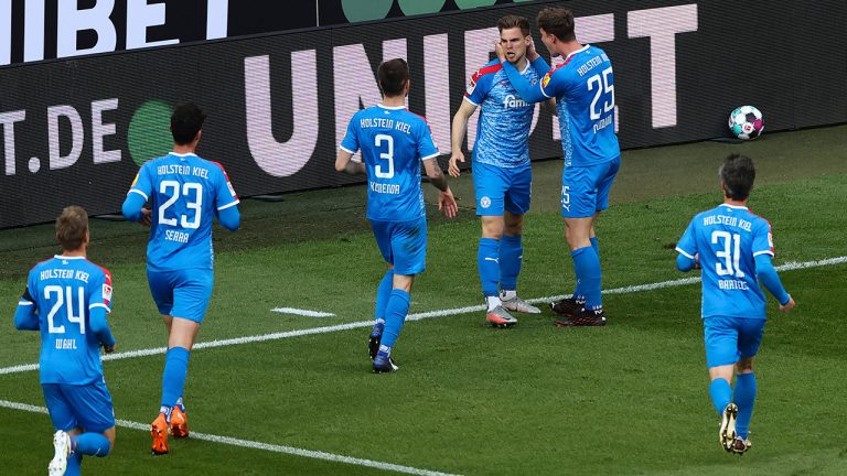 Kiel's Simon Lorenz, centre, celebrates after with teammates after scoring during the Bundesliga relegation match between FC Cologne and Holstein Kiel at the Rhein-Energie-Stadion in Cologne, Germany, Wednesday, May 25, 2021. (Rolf Vennenbernd/Pool photo via AP) 