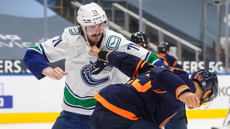 Edmonton Oilers' Darnell Nurse (25) and Vancouver Canucks' Zack MacEwen (71) fight during third period NHL action in Edmonton on Thursday, May 6, 2021. (Jason Franson/CP)