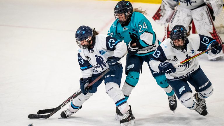 Team Bauer's Erin Ambrose (23) and Alexandra Labelle (13) battle with Team Sonnet forward Natalie Spooner (24) during Professional Women's Hockey Players Association (PWHPA) Secret Dream Gap Tour action at the Seven Chiefs Arena on the Tsuut'ina Nation near Calgary, Alta. in this Thursday, May 27, 2021 handout photo. (Dave Holland/PWHPA)