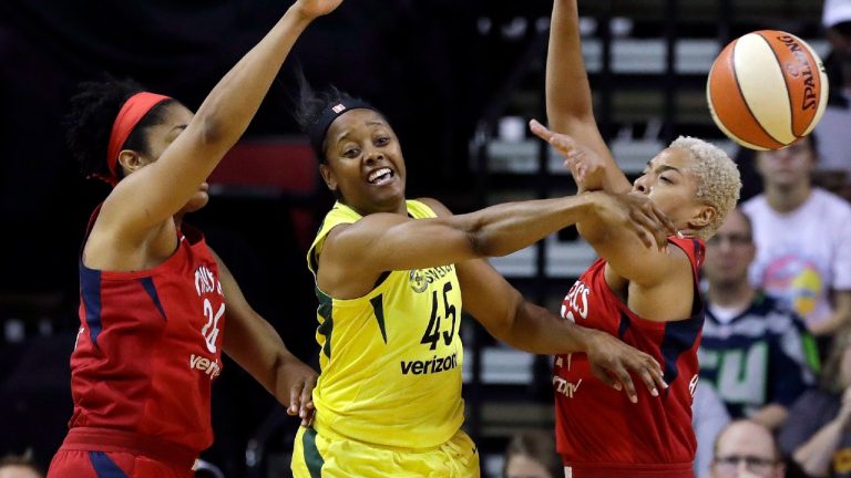 Seattle Storm's Noelle Quinn (45) passes the ball away from Washington Mystics' Krystal Thomas, left, and Tianna Hawkins during the second half of Game 1 of the WNBA basketball finals Friday, Sept. 7, 2018, in Seattle. The Storm won 89-76. (Elaine Thompson/AP) 