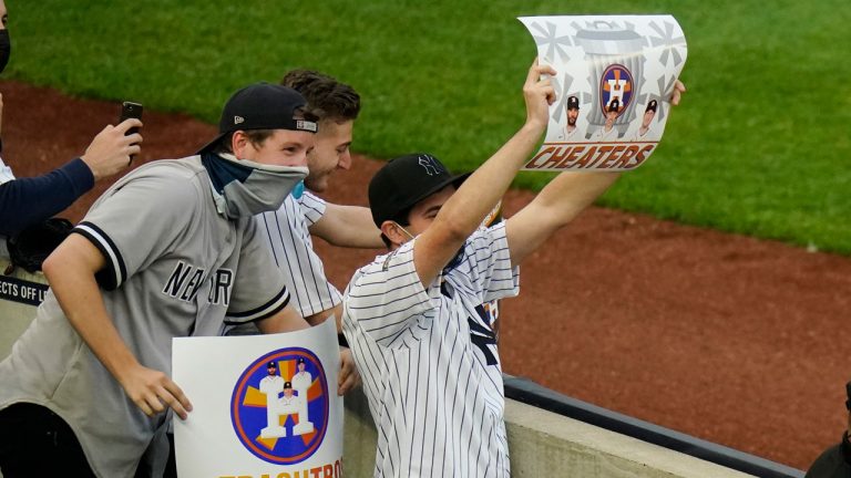 New York Yankees fans hold signs before the start of a baseball game between the New York Yankees and the Houston Astros. (Frank Franklin II/AP)