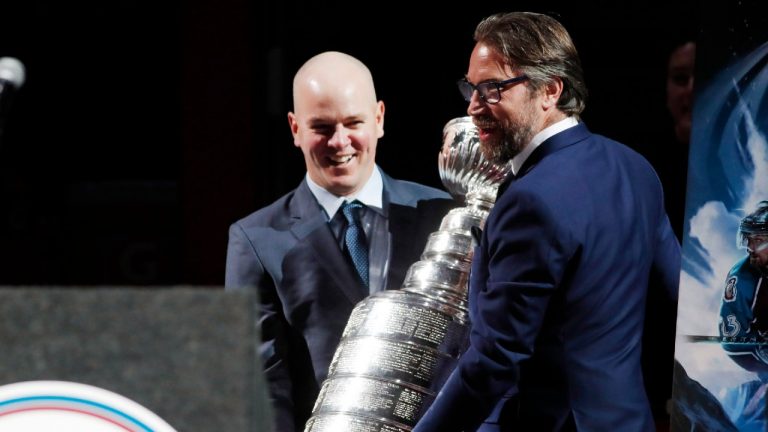 Alex Tanguay, left, and Peter Forsberg carry out the Stanley Cup during a ceremony to retire the number worn by teammate Milan Hejduk. (David Zalubowski/AP)